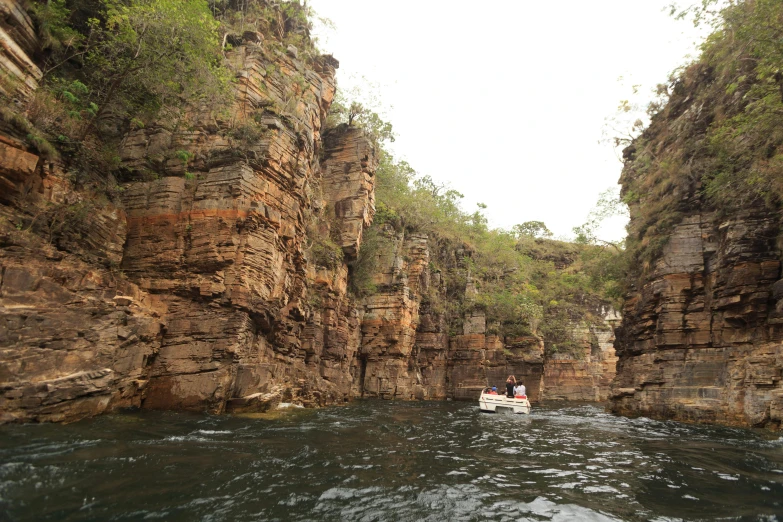 people on a boat in a canyon with steep sides