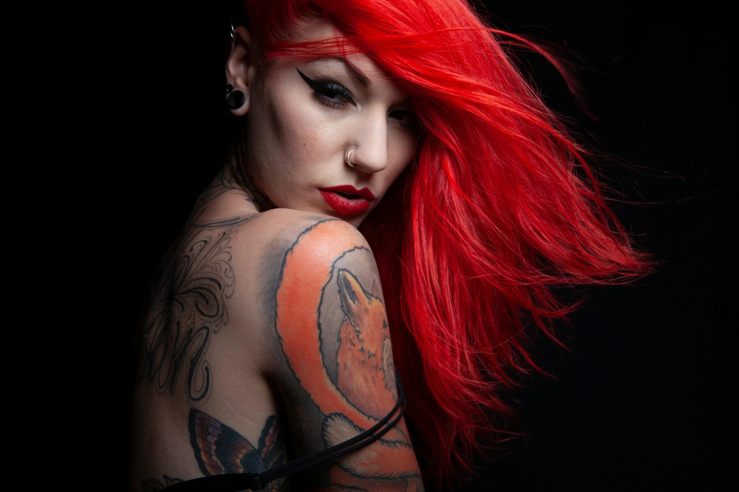 a woman with red hair and piercings on her chest