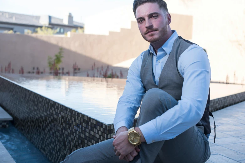 man in business attire sitting in front of a pool