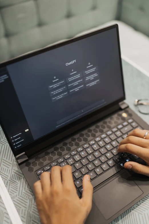 person operating a laptop on a small table