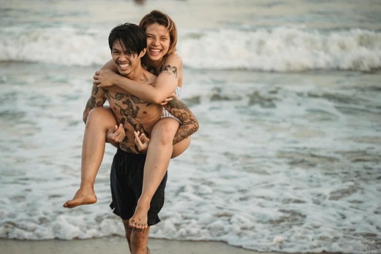 a young couple hugging and cuddling in front of the ocean