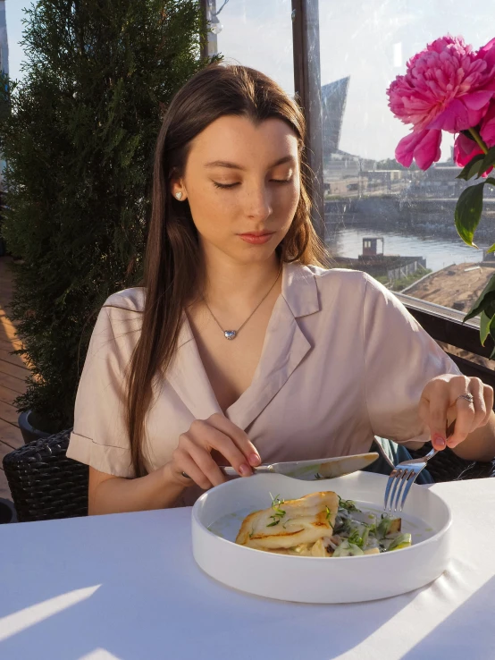 the woman is sitting outside having a meal