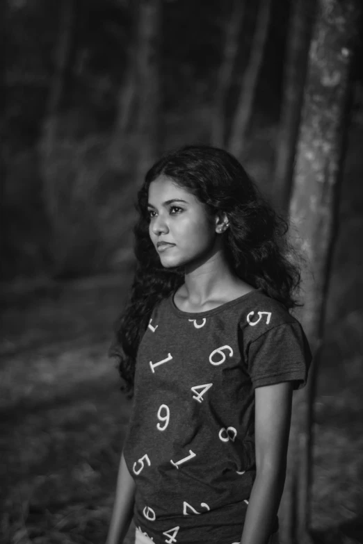 black and white pograph of girl in front of tree