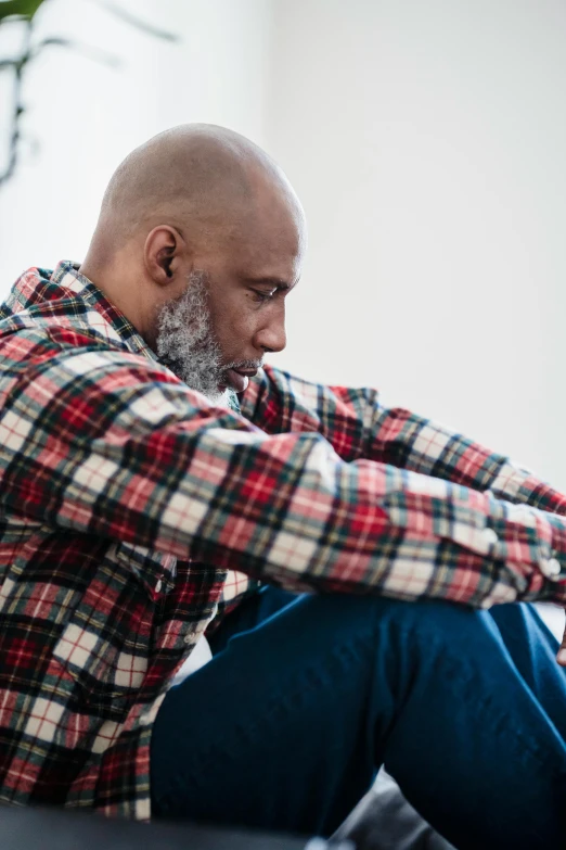 a bald man sitting down on the floor