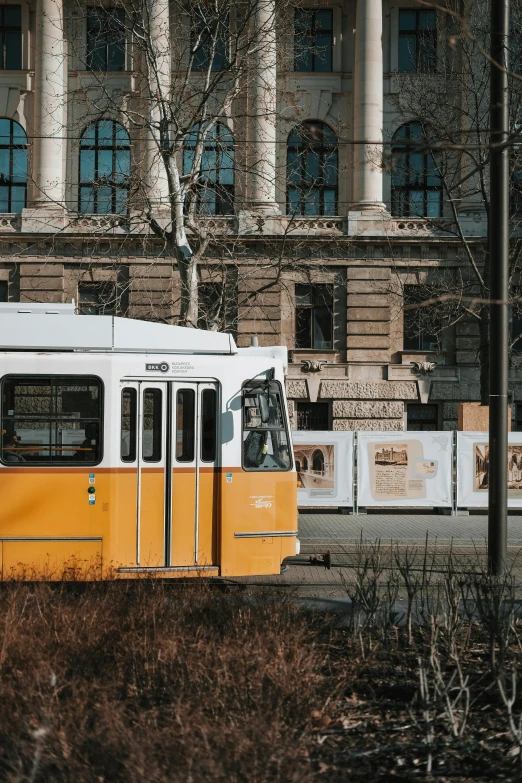 a yellow bus that is parked in front of a large building