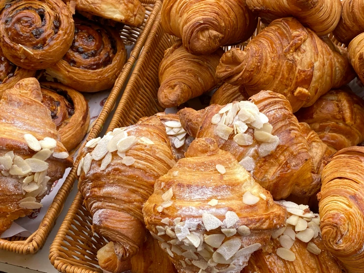 pastries and breads are arranged in baskets at a market