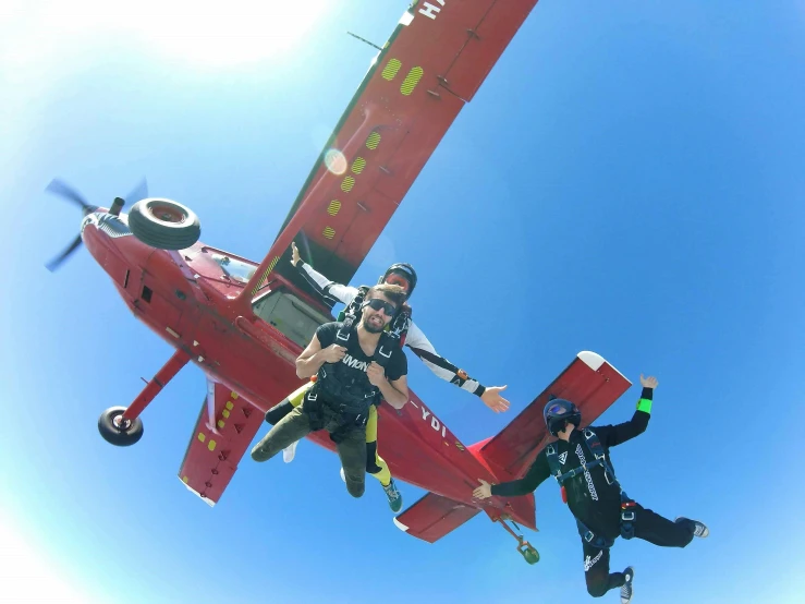 a group of people jumping in the air with a helicopter