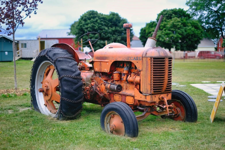an old rusted out farm tractor sitting in the middle of a field