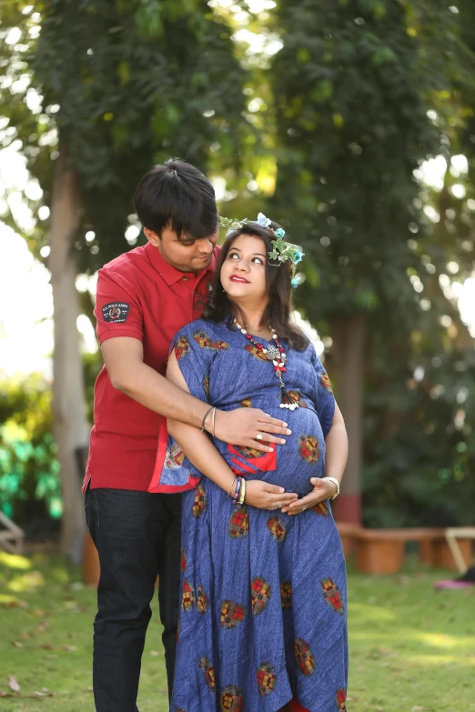 a young man kissing a pregnant woman