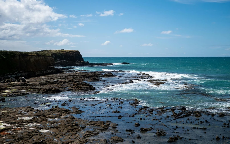 an ocean and a cliff side by sea