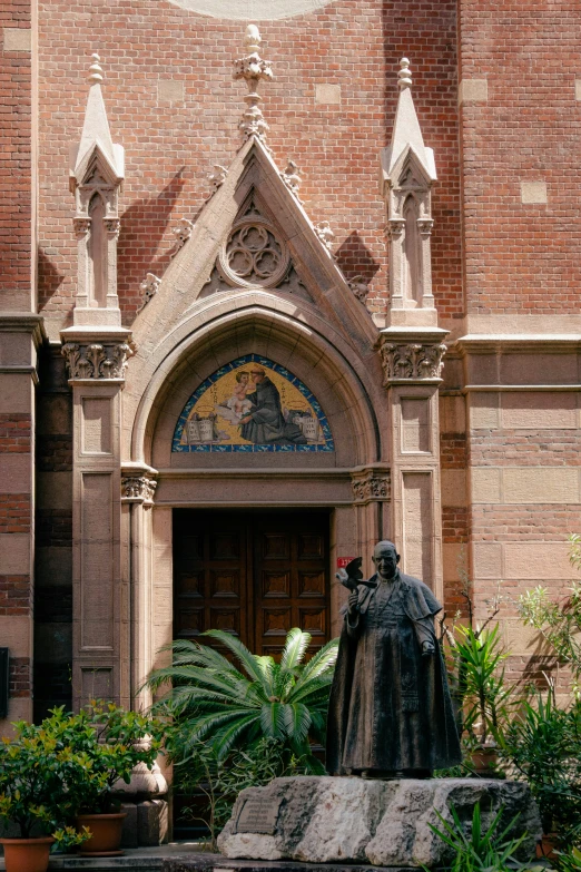 the statue stands by the doors and window of the cathedral