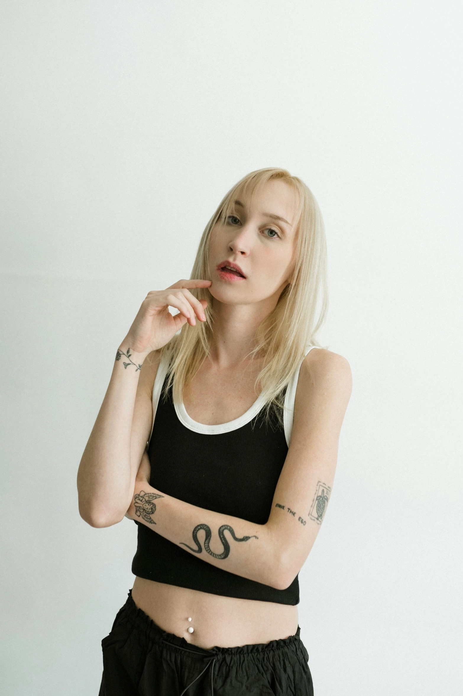 a woman with tattoos is standing in a studio