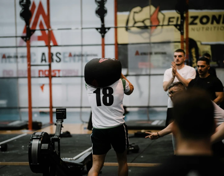 men practicing martial in a building with people watching