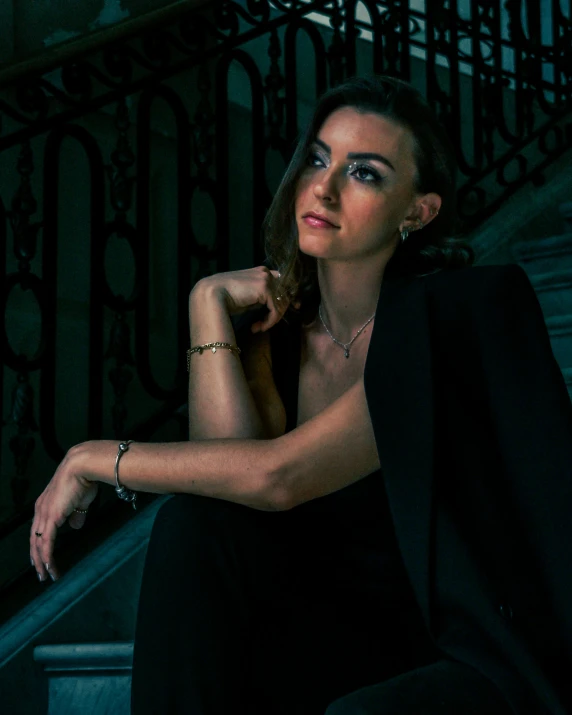 a woman leaning on a metal railing with her hand over her head