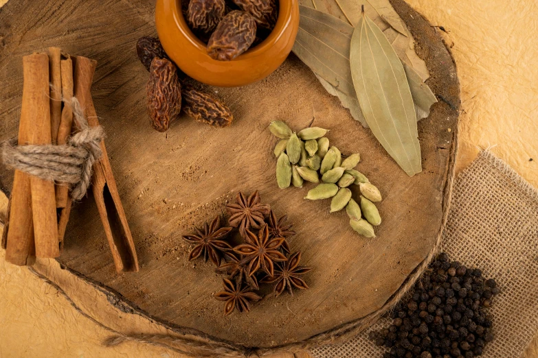 many spices sit in a bowl next to some cinnamons