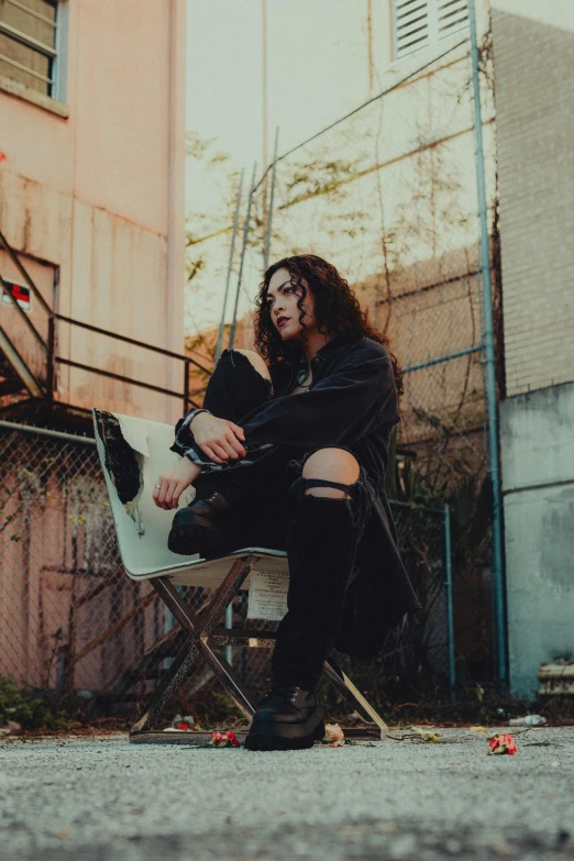 a young woman sitting on a chair outside