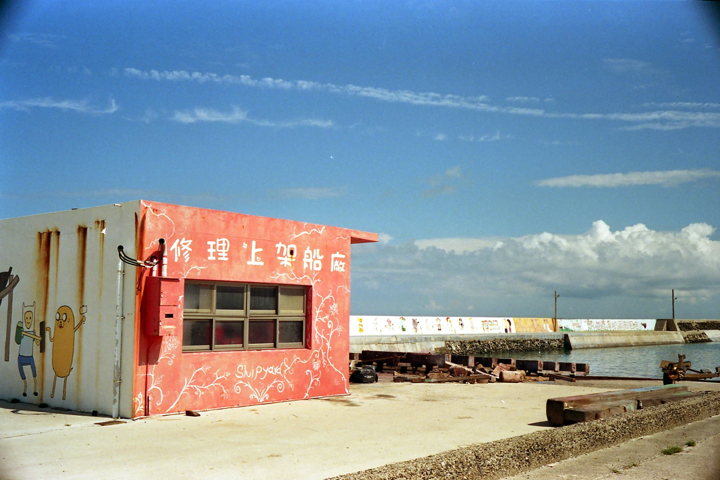 a building painted in different colors with two people walking by