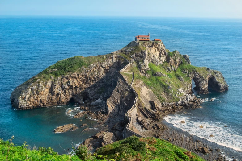 a castle standing on top of a large hill on a cliff near the ocean