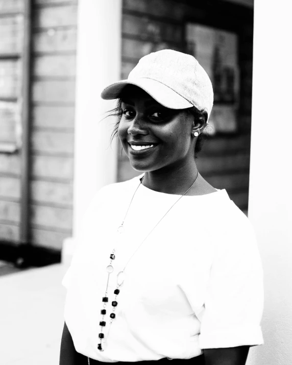 a woman is standing outside wearing a hat and sunglasses