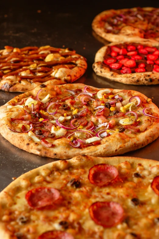 a number of cooked pizzas being prepared to be eaten