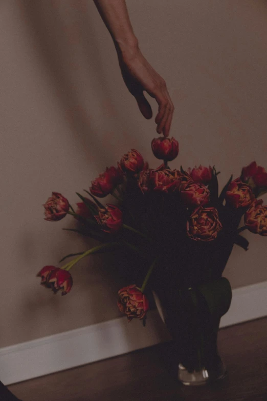 a man grabbing flowers into a vase