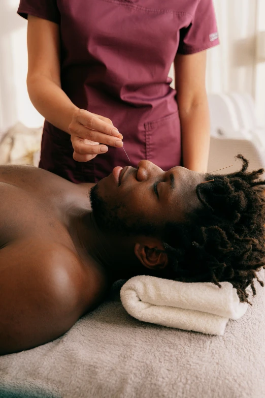 the woman is in the spa getting her face touched