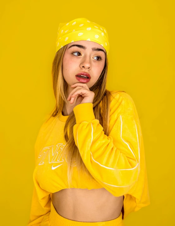 a girl is shown wearing yellow clothing and making her face