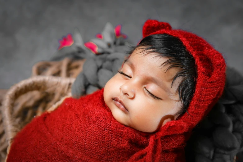 a baby with his head out sleeping under a blanket