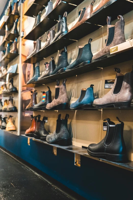 many different shoes are displayed on wooden shelves