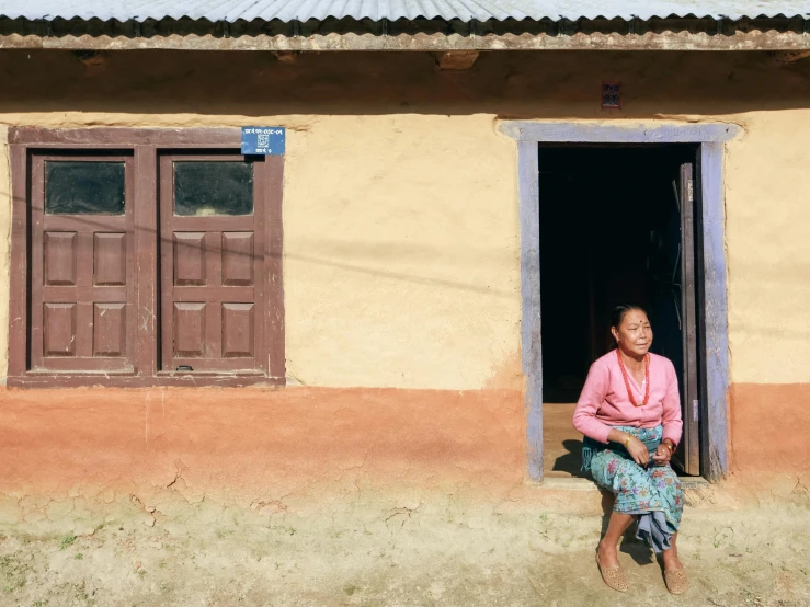 a woman sitting in a doorway with her legs crossed