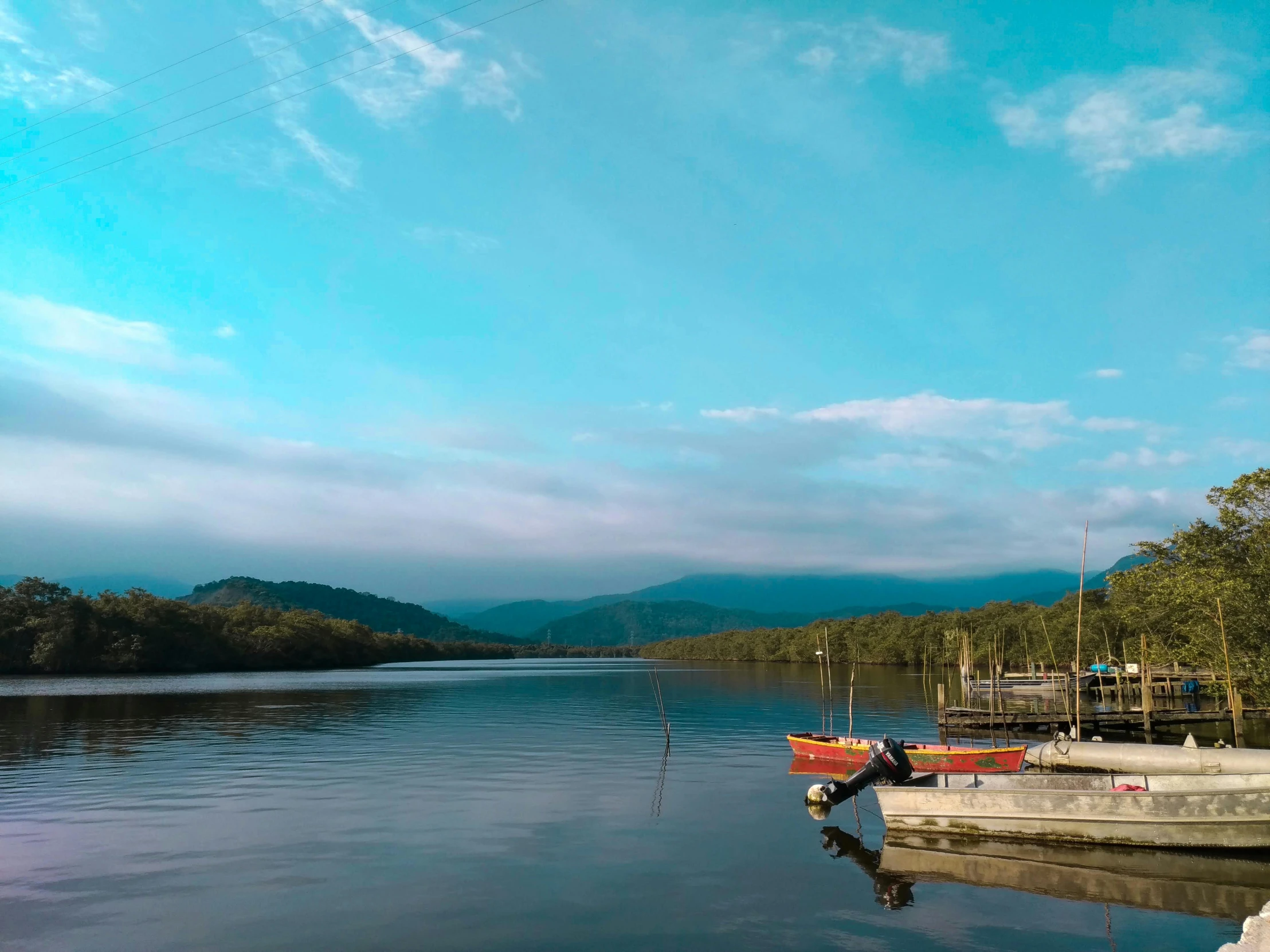 boats on water during daytime with mountains in background