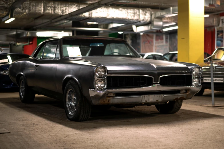 an old car parked in a garage that has faded paint