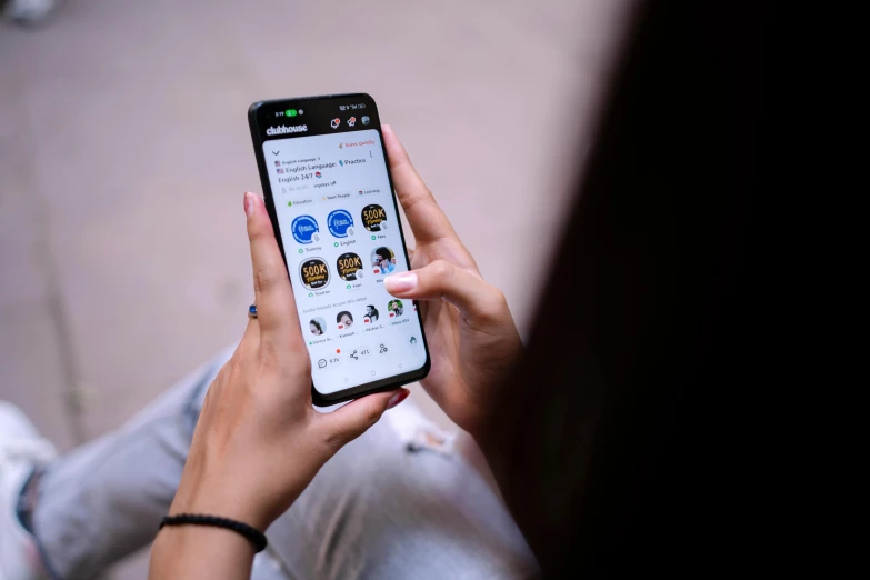 a woman holding up a smart phone with multiple icons