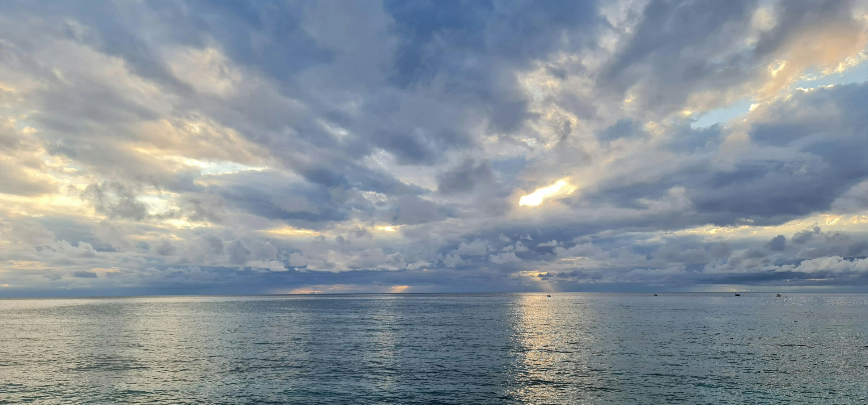 a lone boat on the ocean during sunset