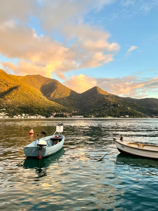 two boats are sitting in the water near mountains