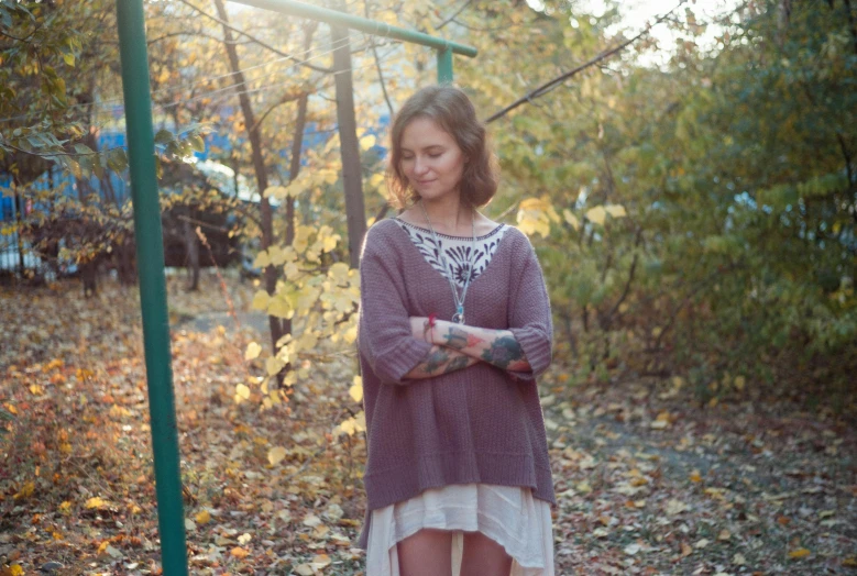 a woman in the middle of leaves looking at soing