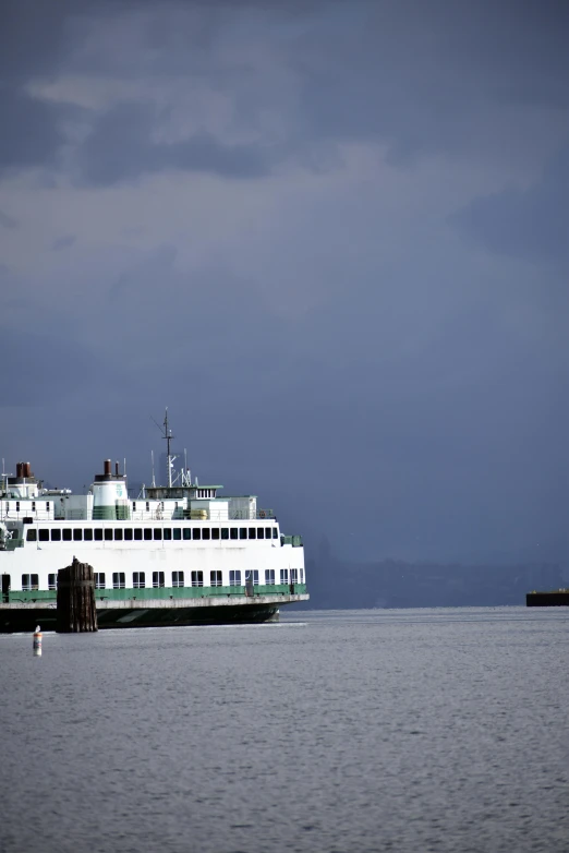 ferry boat docked in the ocean under stormy skies