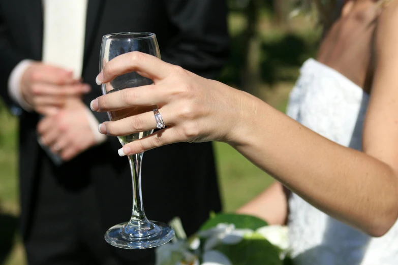 a person holding a wine glass with someone in the background