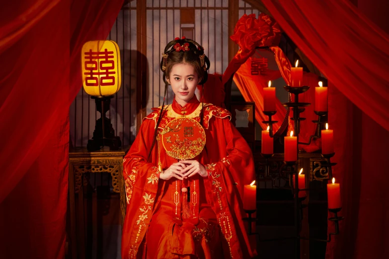 a beautiful woman wearing an oriental outfit posing in front of candles