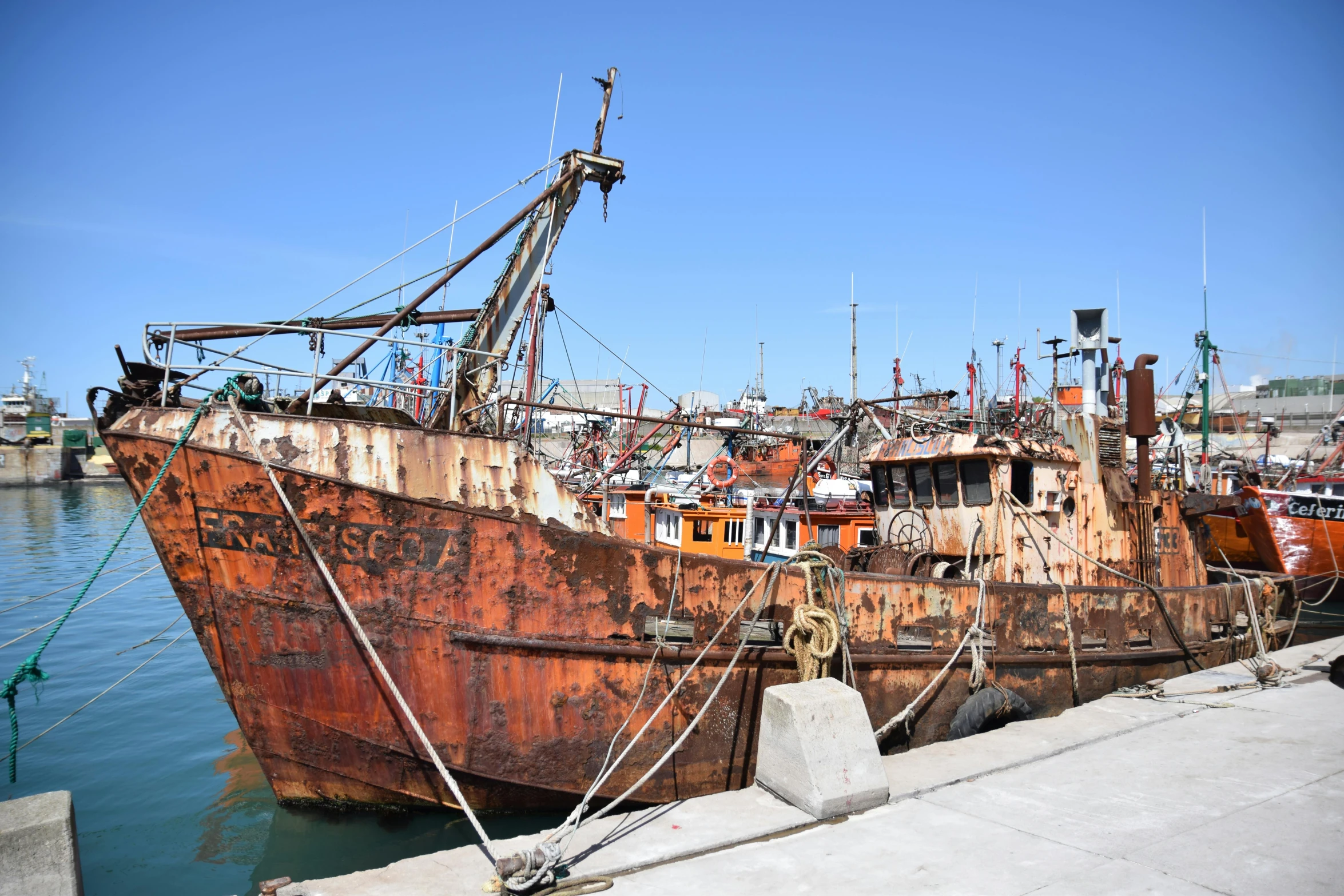 a rusty ship that has been pulled up to shore