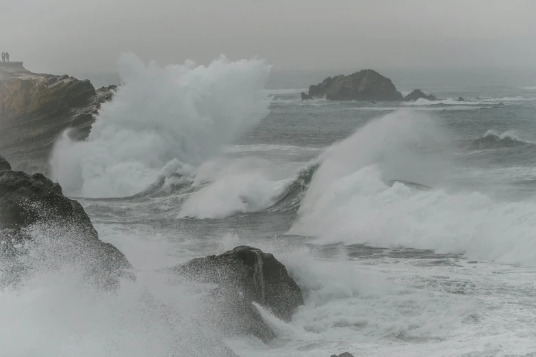 the waves crash into a beach on a windy day