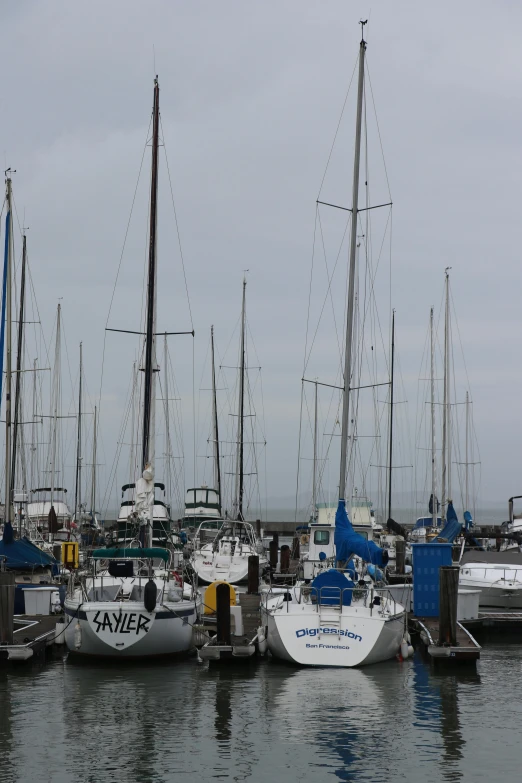 sail boats are sitting docked at the pier