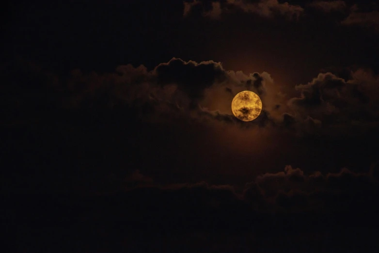 a full moon seen from the clouds during the night