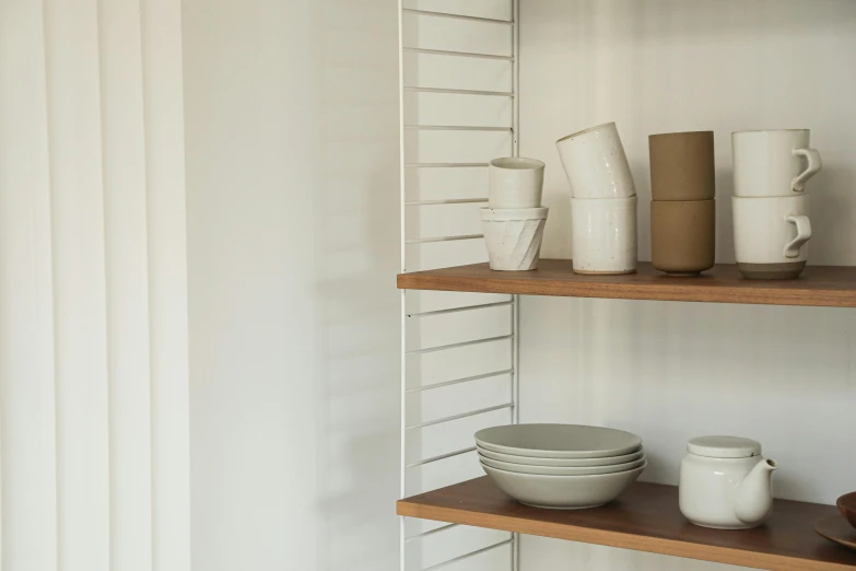 a shelf filled with cups and plates on top of wooden shelves