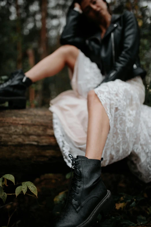 a woman sits on a log in the woods