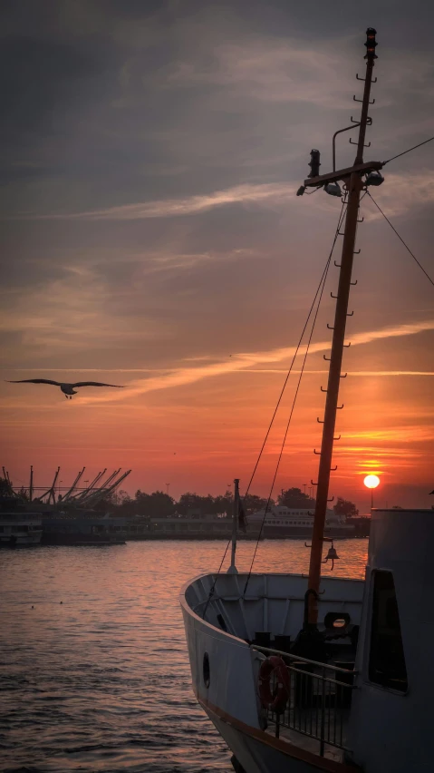 a boat sitting in the water near a sunset