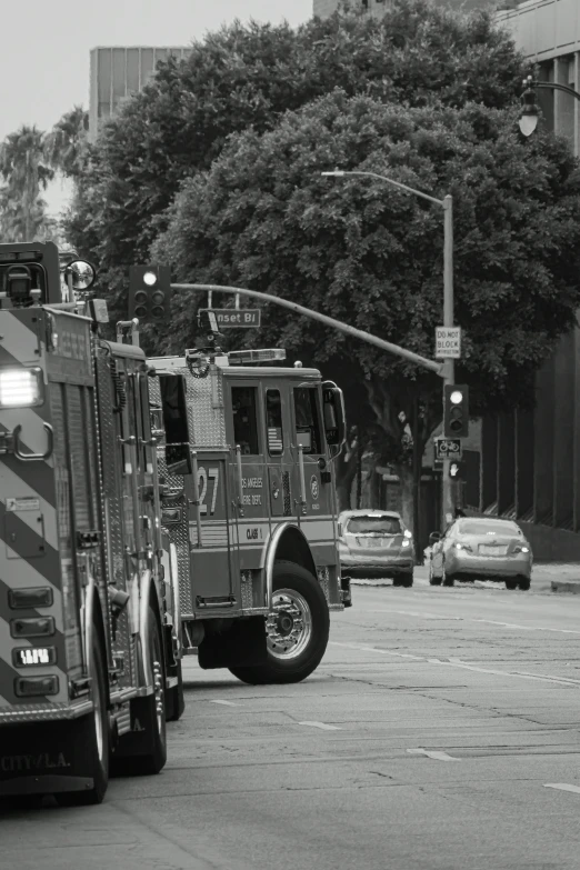 two firetrucks driving down the street next to each other