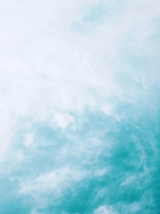 an airplane flies in the sky in front of cloudy skies