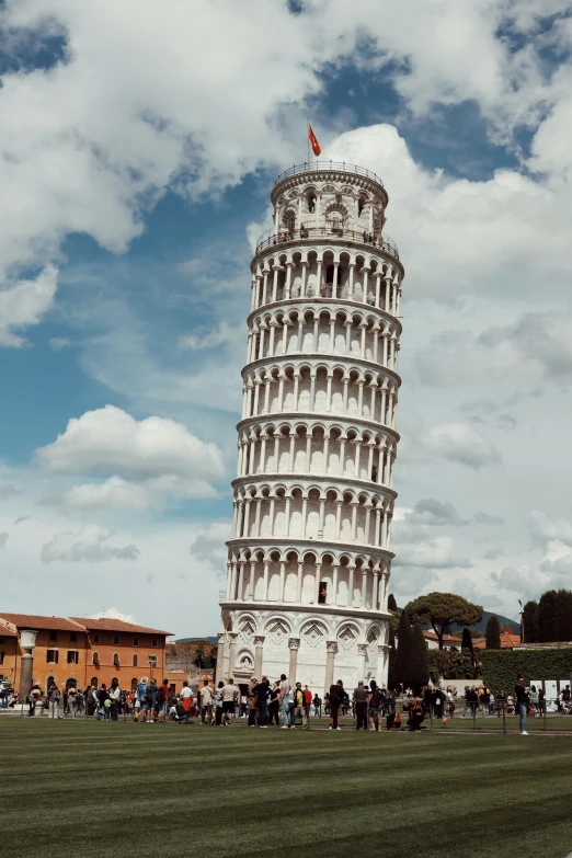 a tall tower with people inside sitting on the grass