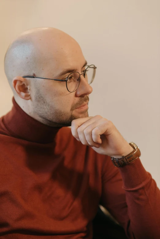 a bald man in glasses looking off into the distance